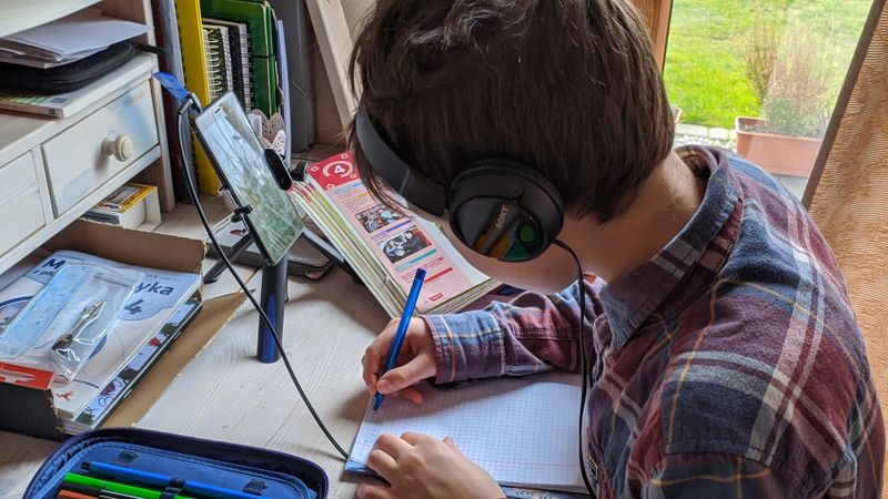 Étudiant suivant un cours à distance avec un casque audio